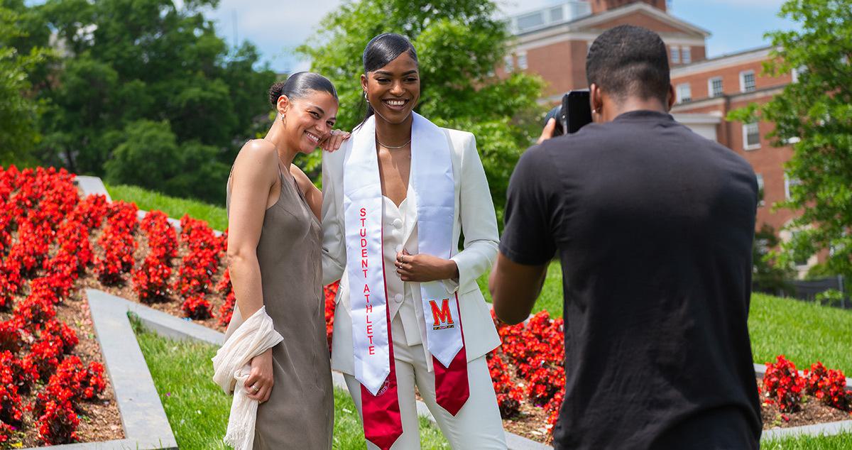 Graduate and family standing in front of "the M". Photographer snaps photo