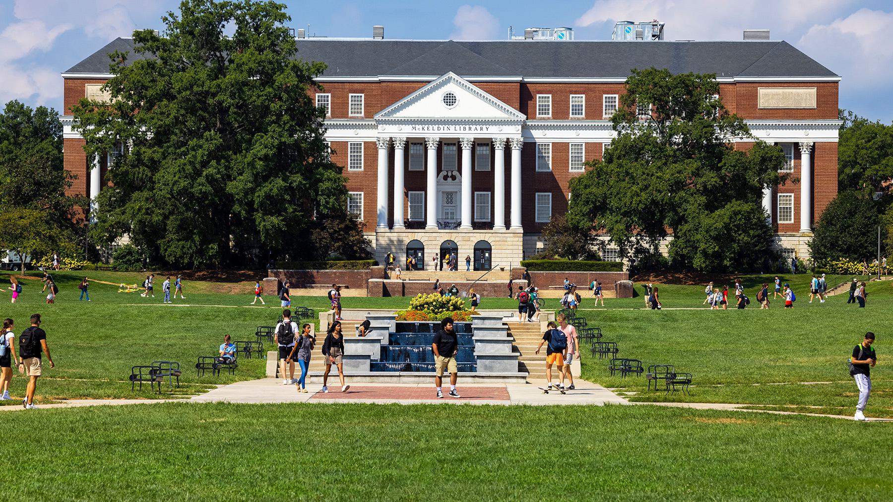 Large traditional building with columns - McKeldin Library. Fountain pools in front with student walking on pathways