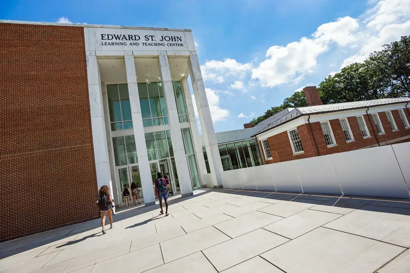 Exterior of a modern building on university campus. Edward St. John Teaching & Learning Center. Students walking in front.