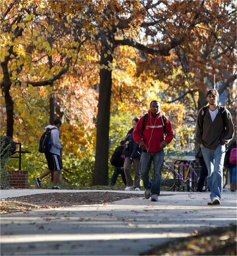 Student walking around campus on a nice fall day