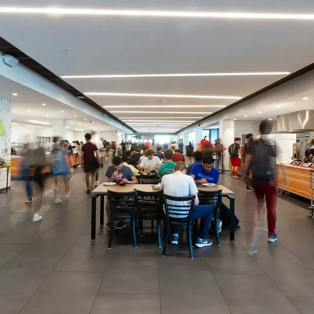 View of dining hall with lots of people, some in motion blur.