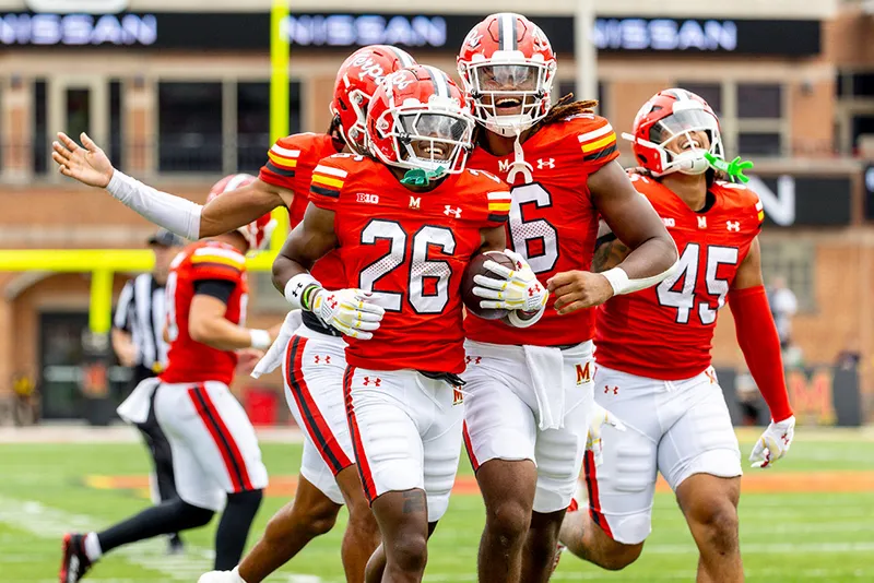 Football players on the field in uniform smiling