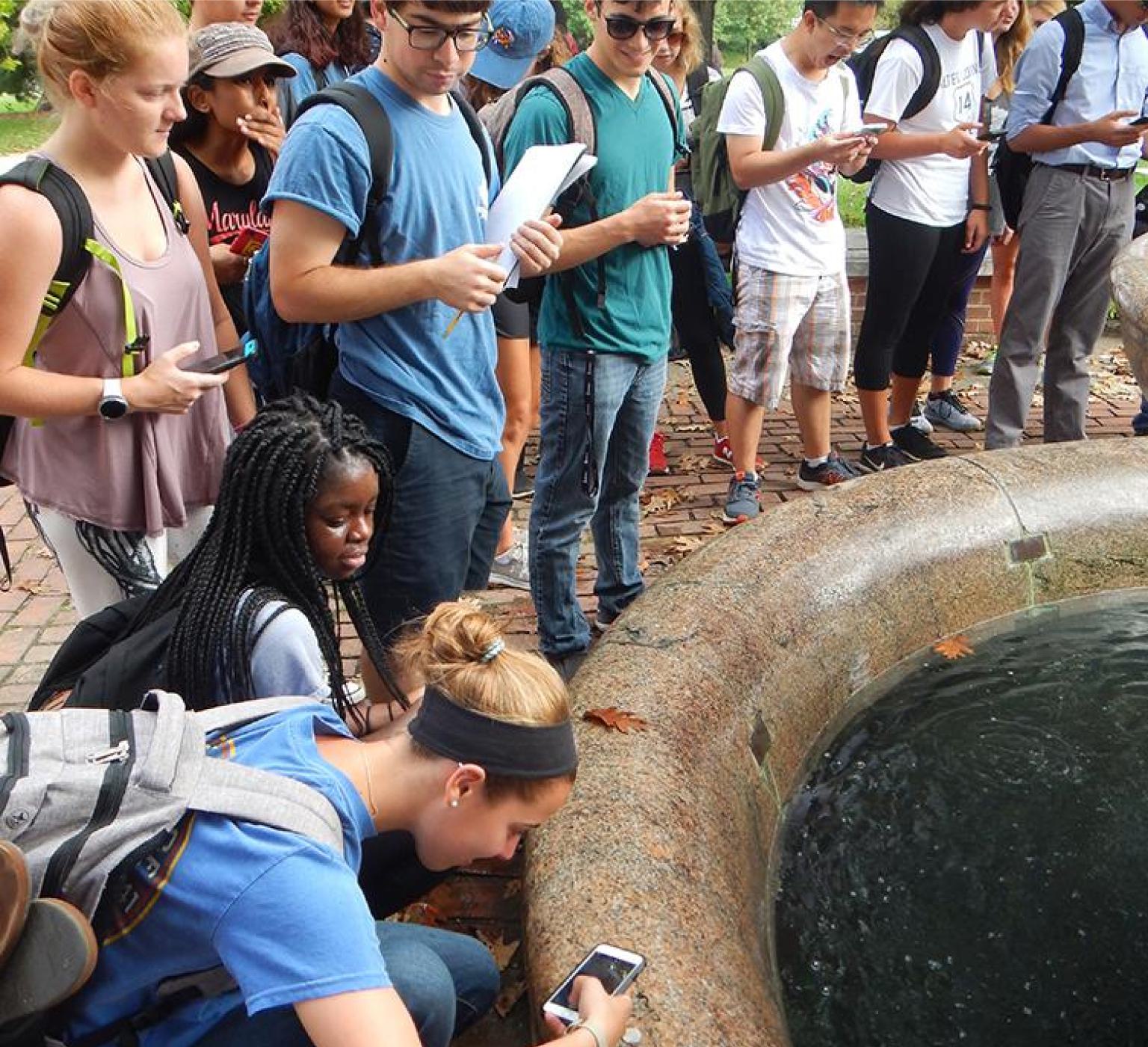 A group of students lined up around a body of water