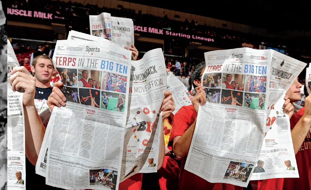 Students reading newspapers during a game