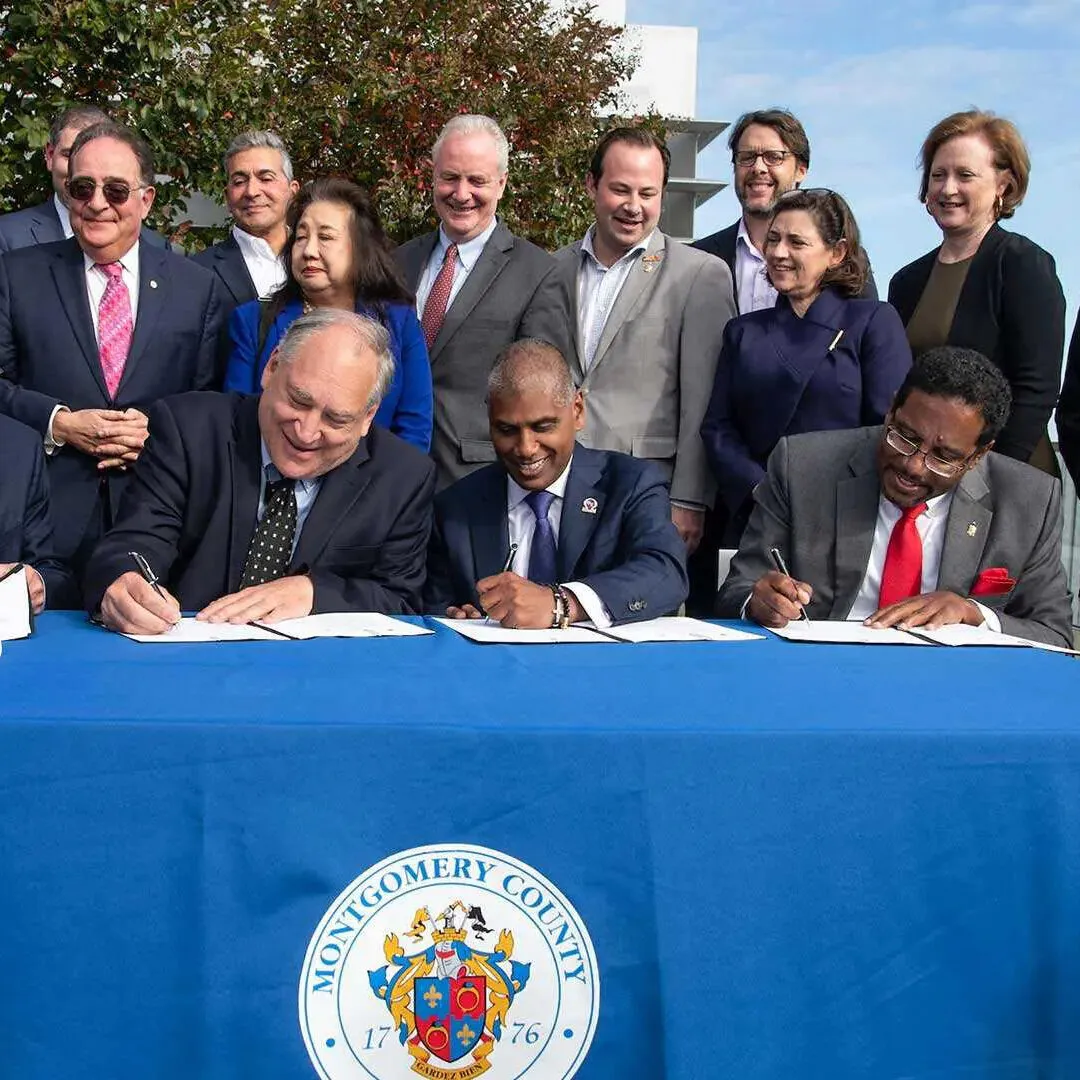 Business people, Dr. Pines, political leaders gathered, signing partnership