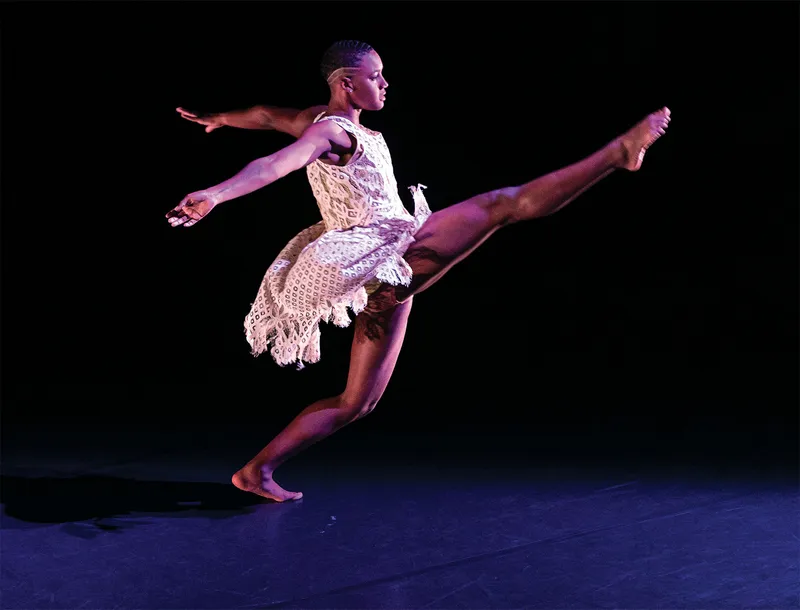 dancer on stage with leg extended, arms back