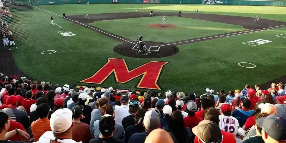 Baseball diamond with a few players on field, view from top of stands. "M" in center on field.